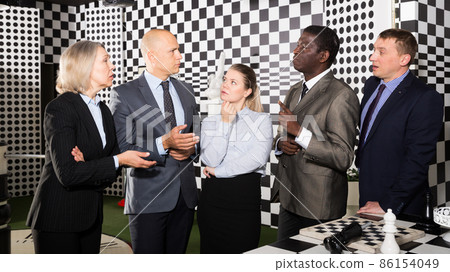 Business partners discussing in chess escape room Business partners discussing in chess escape room 86154049