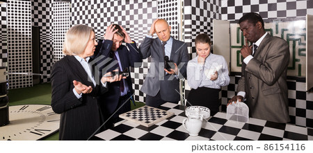 Businesspeople solving conundrum together near chessboard Businesspeople solving conundrum together near chessboard 86154116