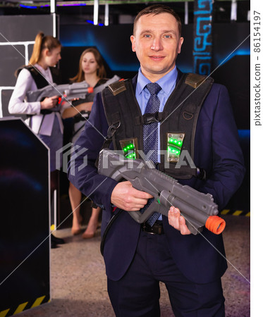 Man holding laser gun and playing laser tag Man holding laser gun and playing laser tag 86154197