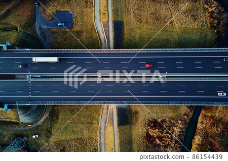 Aerial view of highway with moving cars Aerial view of highway with moving cars 86154439