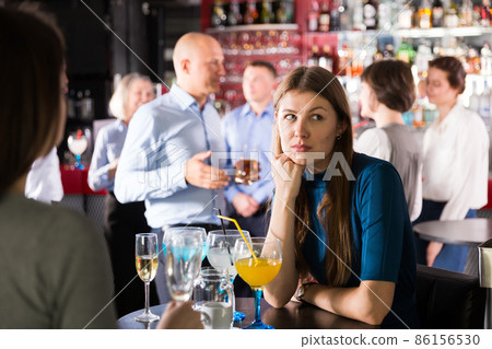 Upset young woman at corporate bar party 86156530