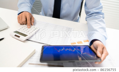 Working Man Conept The office man holding tablet and pressing the calculator while sitting in the office 86156755