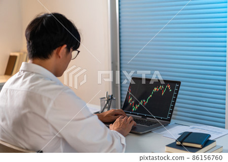 Overwork Concept The office employee working at the office by analyzing the graph on his laptop screen 86156760