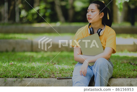 A teenage woman holding a tablet with a worried expression. 86156953