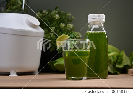 Fresh green vegetable smoothie with vegetables and blended on wooden table. Fresh green vegetable smoothie with vegetables and blended on wooden table. 86158334