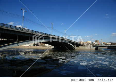 Bolshoy Ustinsky Bridge in Moscow, Russia-- is a steel arch bridge that spans Moskva River near the mouth of Yauza River, connecting the Boulevard Ring with Zamoskvorechye district Bolshoy Ustinsky Bridge in Moscow, Russia-- is a steel arch bridge that spans Moskva River near the mouth of Yauza River, connecting the Boulevard Ring with Zamoskvorechye district 86159347