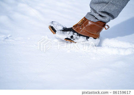 Walking on a snowy road (snow shoes) Walking on a snowy road (snow shoes) 86159617