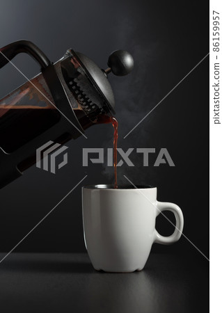 Pouring French press coffee into a cup. Pouring French press coffee into a cup. 86159957