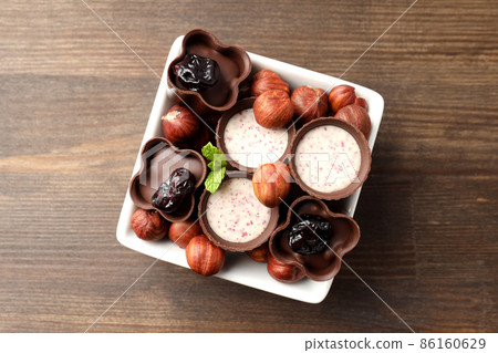 Concept of sweets with chocolate candies on wooden background Concept of sweets with chocolate candies on wooden background 86160629