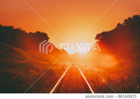 Railway In Dramatic Sunset Backlight. Scenic View Of Railway Going Straight Away In Sunlight. Transportation And Travel Railroad Concept 86160915
