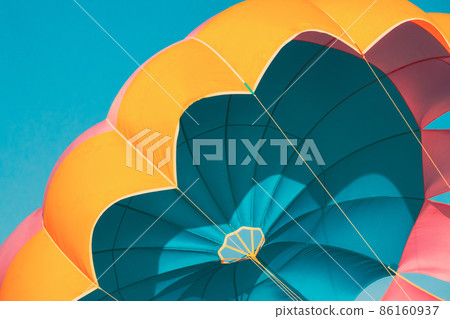 Close Multi-colored Parachute For Parasailing On Background Of Blue Sky Close Multi-colored Parachute For Parasailing On Background Of Blue Sky 86160937