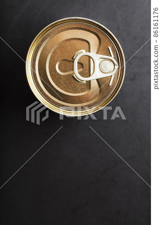 The lid of a metal tin can on a black background 86161176
