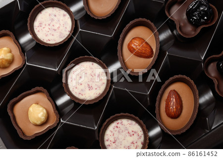 Chocolate candies in box all over background, close up 86161452