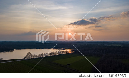 Aerial view shot by a drone of a beautiful dramatic and colorful sunset at coast of the lake. Nature 86162085