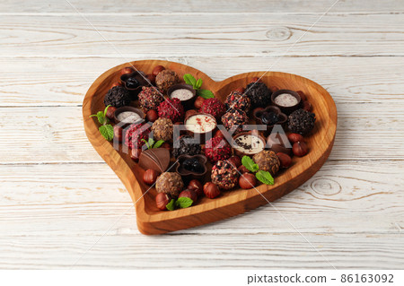 Concept of sweets with chocolate candies on white wooden background Concept of sweets with chocolate candies on white wooden background 86163092