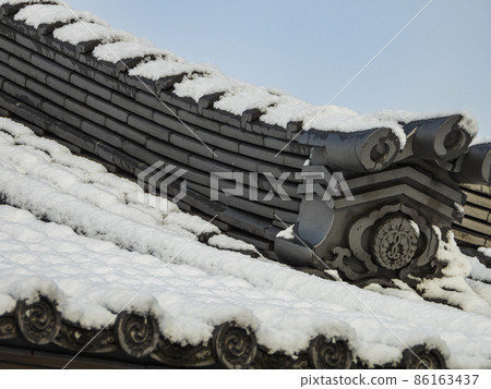 Tile roof of a temple with snow 86163437