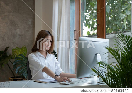 Thinking about business. Thoughtful young woman looking at computer screen while sitting at his working place at home. Working remotely. Thinking about business. Thoughtful young woman looking at computer screen while sitting at his working place at home. Working remotely. 86163493