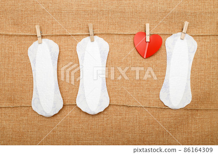 panty liners hanging on clothespins on a textile background. hygiene and protection concept panty liners hanging on clothespins on a textile background. hygiene and protection concept 86164309