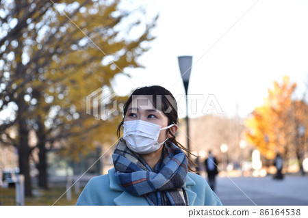 一名日本年輕女子戴著口罩在東京行走，並採取措施防治傳染病 86164538