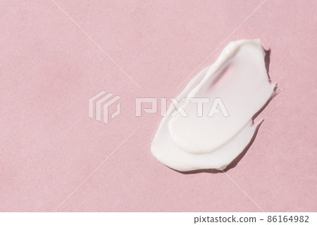 Smear of cosmetic cream on a pink background. 86164982