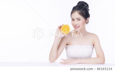 Joyful Asian woman holding fresh orange slices vitamin c for healthy good skin looking at camera Joyful Asian woman holding fresh orange slices vitamin c for healthy good skin looking at camera 86165214