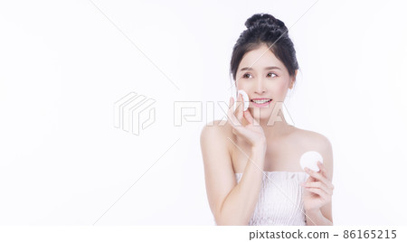 Glamour asian young woman holding white cotton pad removing make-up on white background.  86165215