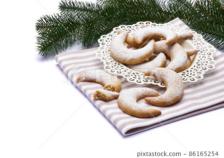 Traditional German or Austrian Vanillekipferl vanilla kipferl cookies on a plate isolated on white background Traditional German or Austrian Vanillekipferl vanilla kipferl cookies on a plate isolated on white background 86165254