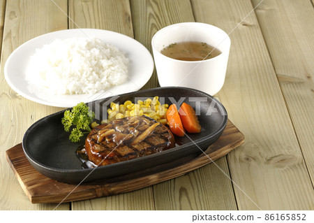 熱日式漢堡牛排配歐芹、玻璃、玉米和蘑菇醬在鐵板上、清湯和米飯 86165852