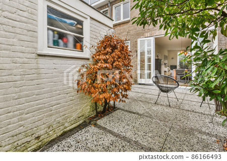 Lovely courtyard of the house with black comfortable chairs 86166493