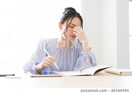 A woman with a tired look at work A woman with a tired look at work 86166494