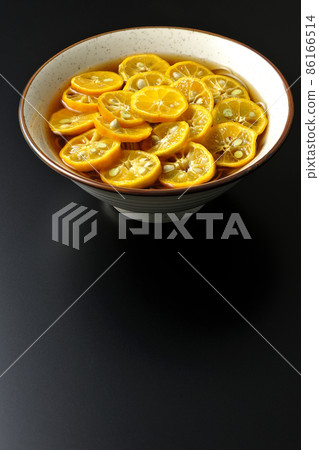 Photographed Sudachi soba with a lot of ripe sudachi slices on a black background Photographed Sudachi soba with a lot of ripe sudachi slices on a black background 86166514