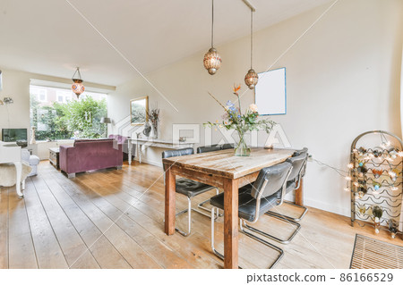 Lovely dining room with hanging chandelier and wooden floor Lovely dining room with hanging chandelier and wooden floor 86166529