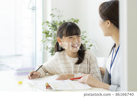 Girl elementary school student receiving individual guidance at a cram school Girl elementary school student receiving individual guidance at a cram school 86166740
