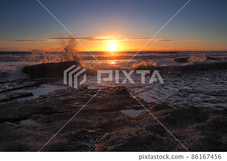 Sunset with clouds and waves crashing onto rocks, Dunraven Bay, South Wales Sunset with clouds and waves crashing onto rocks, Dunraven Bay, South Wales 86167456