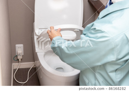 一個穿著工作服的男人正在檢查廁所 86168282