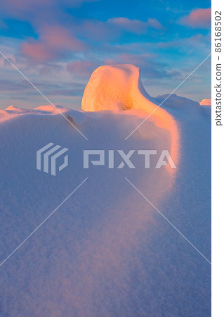 Snowdrift waves in sunset light, purple evening light at winter with a lot of snow, vertical image 86168502