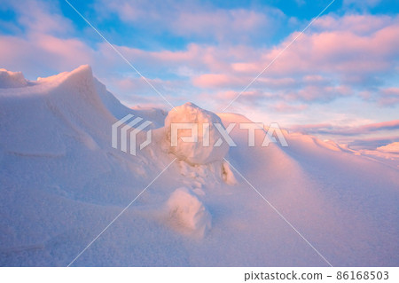 Snowdrift waves in sunset light, purple evening light at winter with a lot of snow, horizontal landscape image Snowdrift waves in sunset light, purple evening light at winter with a lot of snow, horizontal landscape image 86168503