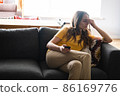 Young woman lying on the couch and using smartphone for speak with friends and relatives. 86169776