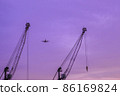 Airplane flying in the violet sky. Travel and flight concept 86169824