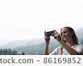 Young millennial woman admires mountains in autumn and taking selfie, picture. 86169852