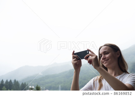 Young millennial woman admires mountains in autumn and taking selfie, picture. 86169852