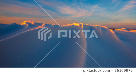 Snowdrift waves in sunset light, purple evening light at winter with a lot of snow, horizontal landscape image Snowdrift waves in sunset light, purple evening light at winter with a lot of snow, horizontal landscape image 86169972