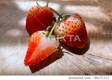 Strawberries placed on a wooden cutting board 86171127