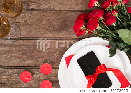 Valentines day table setting with plate, gift, red ribbon and roses. background 86172625