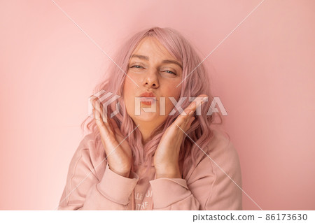 Portrait of happy and positive caucasian woman gives an air kiss over bright pink background 86173630