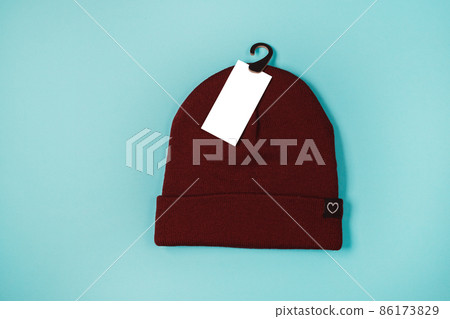 Wool knitted hat on blue background, for mockup template with label with copy space 86173829