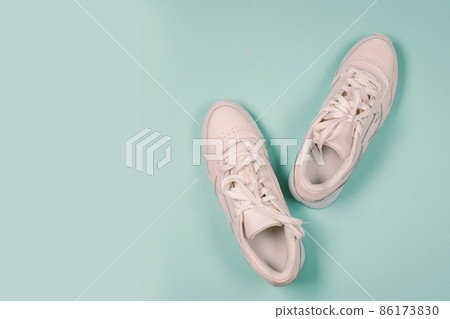 New unbranded running sneaker on blue background. Pair of sports shoes. Fashionable stylish sports casual shoes. Flat lay, top view. Banner 86173830