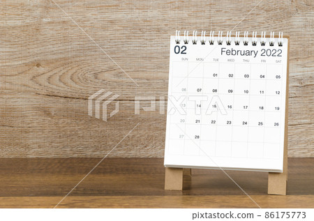 February 2022 desk calendar on wooden background. 86175773