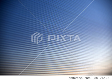Striped blue polycarbonate in the rays of the evening sun Striped blue polycarbonate in the rays of the evening sun 86176322