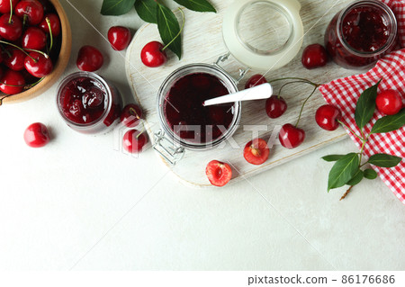 Cherry jam and ingredients on white textured table Cherry jam and ingredients on white textured table 86176686